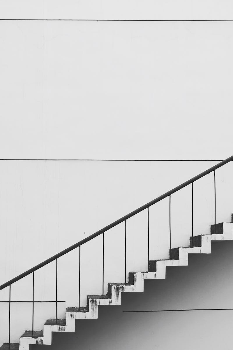 Minimalistic black and white staircase with sharp angles and clean lines, showcasing modern architecture.